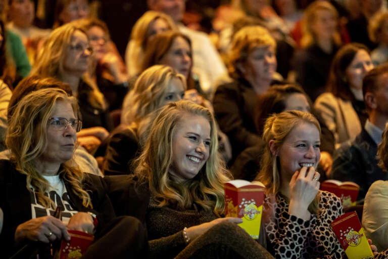 An audience laughing while listening to a performance