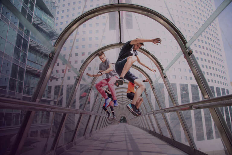 Jongeren doen aan freerunning in een lange, glazen tunnel, waarmee ze de energie van straatactivatie belichamen