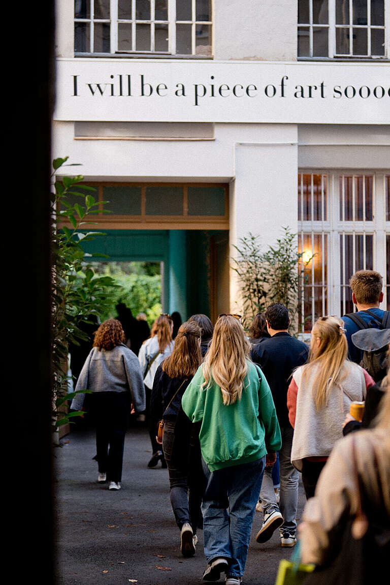 Group entering a building under an inspirational quote, highlighting an engaged and creative culture